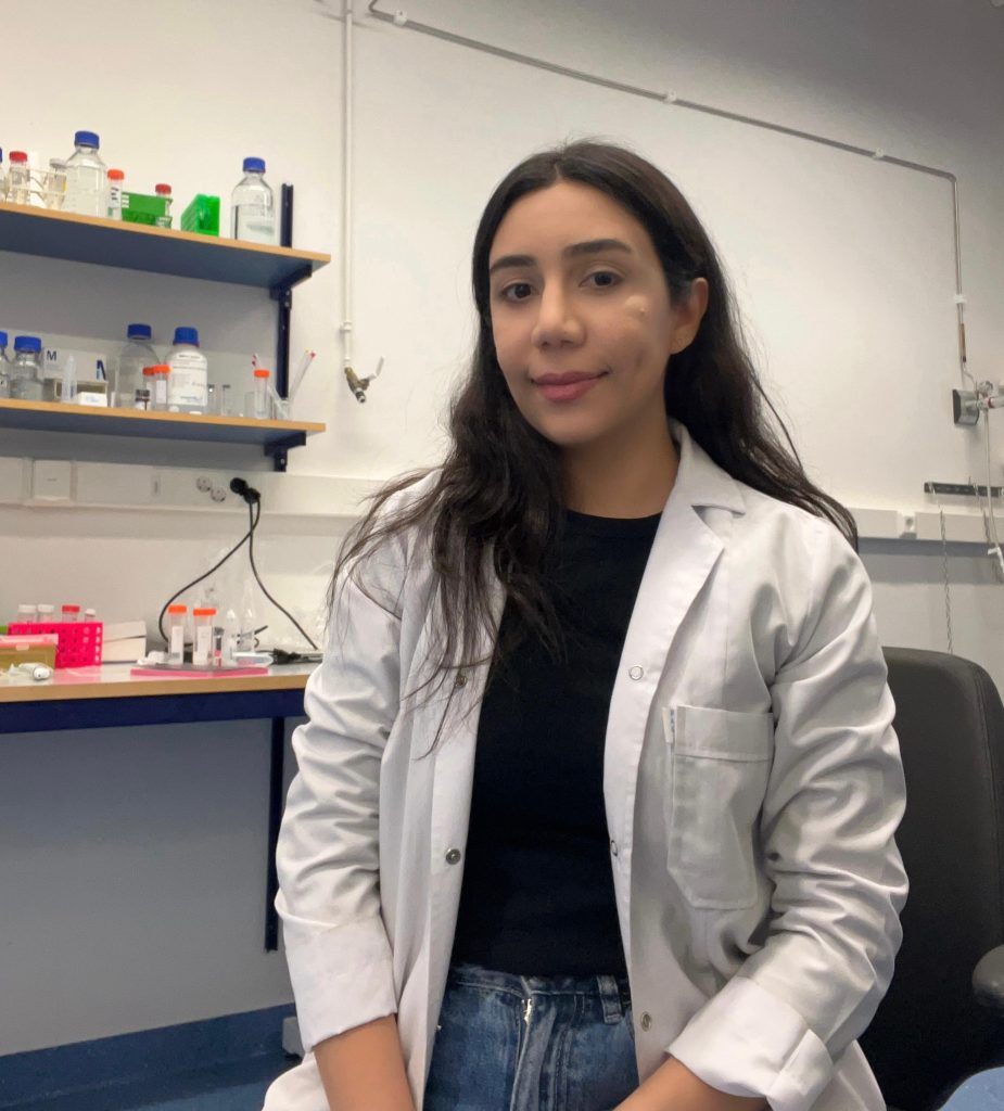 Ceren Yetgin, PharmD, PhD, in a lab coat in the research laboratory